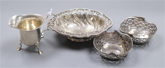 An Edwardian repousse silver bonbon dish, London, 1907, a silver cream jug and pair of silver bonbon baskets.